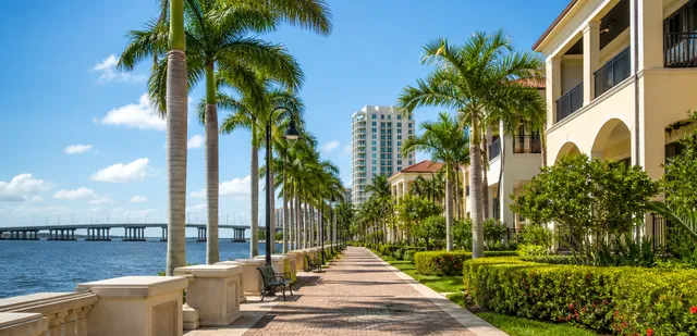 Fort Myers waterfront riverwalk with palm trees and bridge